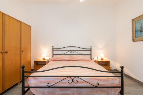 um quarto com uma cama com duas mesas de cabeceira e dois candeeiros em Casa di Giudy em SantʼAntìoco
