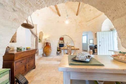 - une grande cuisine avec une table dans une chambre dans l'établissement Trulli Colle Specchia Intera Villa, à Cisternino