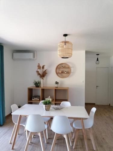 une salle à manger blanche avec une table et des chaises blanches dans l'établissement Gîte Les Demoiselles des Sorgues, à LʼIsle-sur-la-Sorgue