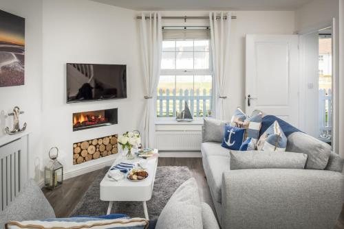 a living room with two couches and a fireplace at Seasalt Camber in Camber