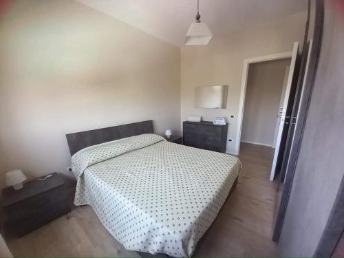 a bedroom with a bed and a night stand and a door at Le dimore di Billa in La Martella