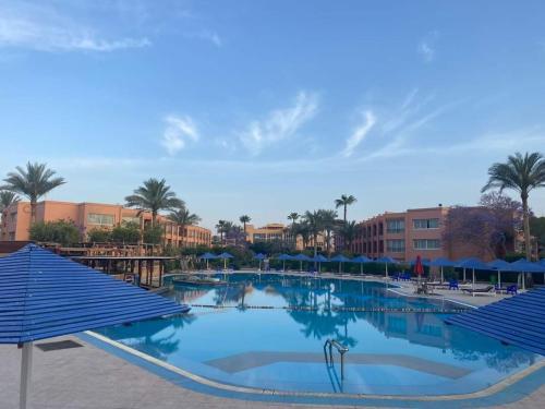 een groot zwembad met blauwe parasols in een resort bij palmera el sokhna in Suez