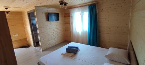 ein Schlafzimmer mit einem Bett mit einer blauen Tasche darauf in der Unterkunft Căsuța din livadă in 2 Mai