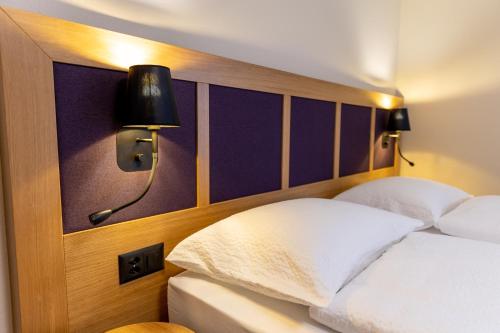 a bedroom with a bed with two lamps on it at Dialoghotel Eckstein in Zug