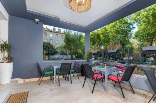 eine Terrasse mit Tischen und Stühlen und einem Fenster in der Unterkunft Marine Lux apartments in Pula