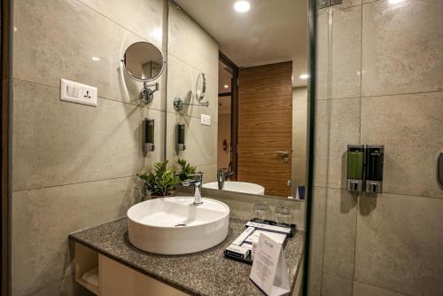 a bathroom with a sink and a mirror at The Sulit Whitefield in Bengaluru