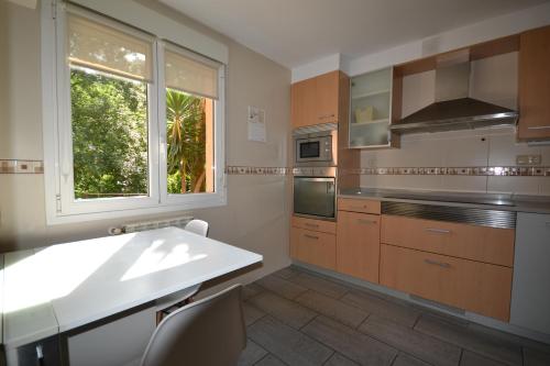 eine Küche mit Spüle und Fenster in der Unterkunft Apartamento Andoaga in San Sebastián