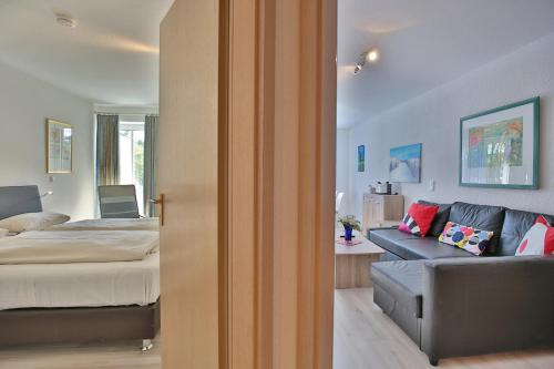 una camera da letto con un letto e un divano in una stanza di Residenz Ostseestrand Appartement 4 a Scharbeutz