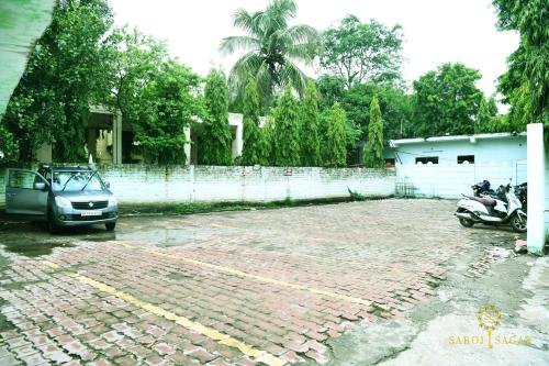 a car and a motorcycle parked in a parking lot at Hotel Saroj Sagar in Sāgar