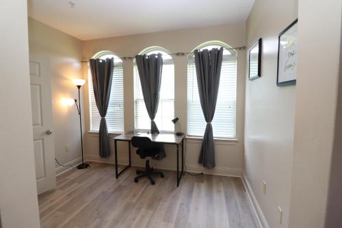 a home office with a desk in front of two windows at 1 BR 1BA Oasis Near LSU and Casino Free Parking in Baton Rouge