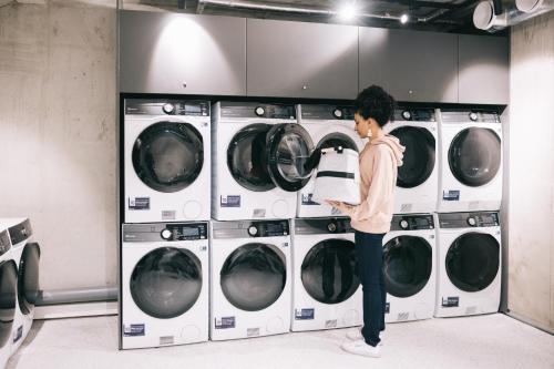 a woman standing in front of four washing machines at Rocca House by Larsen in Tallinn