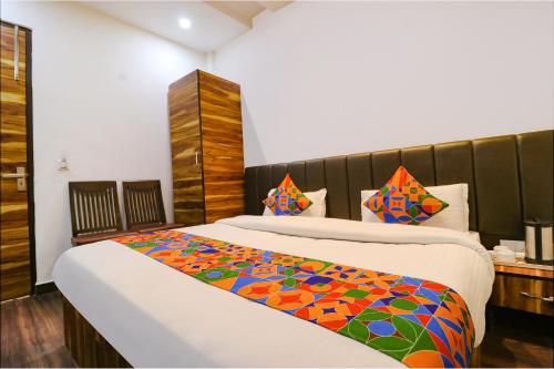 een slaapkamer met een bed met een kleurrijke deken erop bij FabHotel JP Residency in Amritsar
