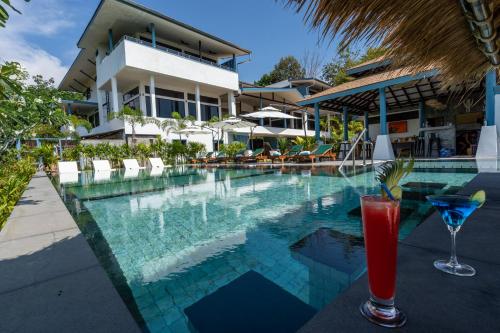 a drink sitting on a table next to a swimming pool at Villa Lila in Ko Lanta