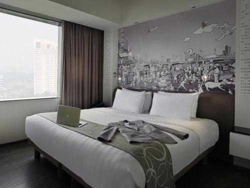 a hotel room with a bed with a laptop on it at Mercure Jakarta Simatupang in Jakarta