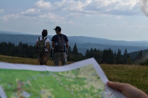 two people standing on a hill looking at a map at Mountain-Rest Pension in Miercurea-Ciuc