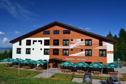 a large building with green umbrellas in front of it at Mountain-Rest Pension in Miercurea-Ciuc