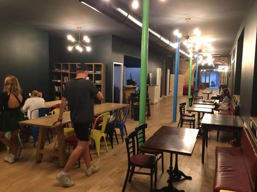 a man is standing at tables in a restaurant at HOSTEL20 Bordeaux HIFRANCE in Bordeaux