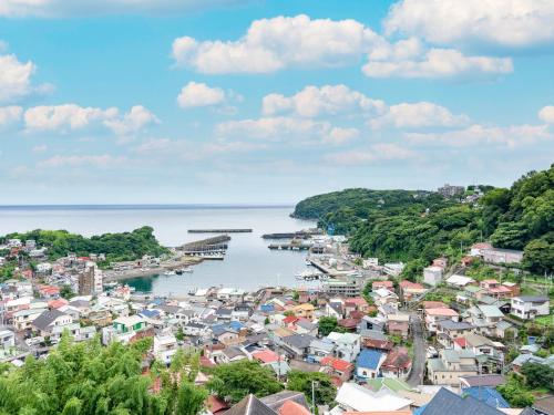 a view of a town next to a body of water at Tabist Miyoshi Ryokan Odawara Manazuru in Odawara