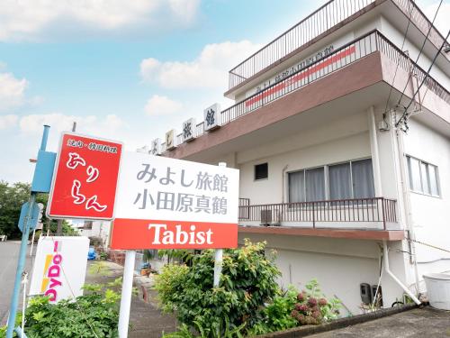 a hotel sign in front of a building at Tabist Miyoshi Ryokan Odawara Manazuru in Odawara