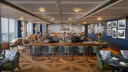 a bar in a restaurant with green chairs at Hyatt Regency Phnom Penh in Phnom Penh