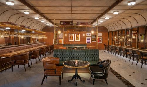 a bar with a green bench and tables and chairs at Hyatt Regency Phnom Penh in Phnom Penh
