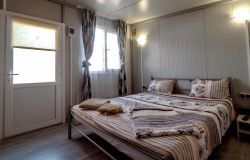a bedroom with a bed and a window and a door at Cazare Sulinaa in Sulina