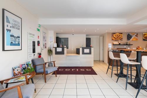 a room with chairs and a table and a kitchen at Cerise Nantes Atlantis in Saint-Herblain