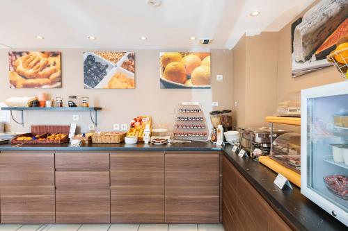 a bakery with a counter with bread and pastries at Cerise Nantes Atlantis in Saint-Herblain