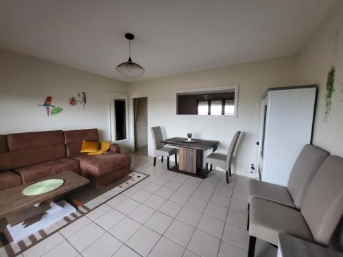 - un salon avec un canapé et une table dans l'établissement DL LES 4 SAISONS - Meublé Tourisme 3 Etoiles, à Brive-la-Gaillarde