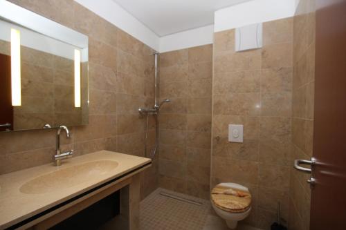 a bathroom with a shower and a sink and a toilet at Hotel Da Gianni GmbH in Oranienburg