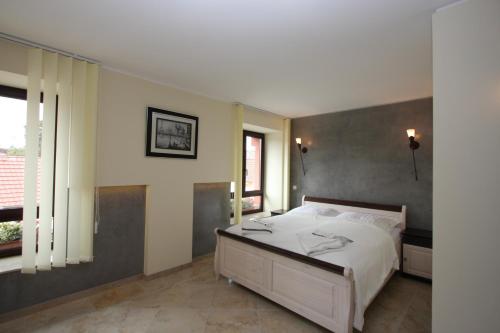 a bedroom with a white bed and a large window at Hotel Da Gianni GmbH in Oranienburg