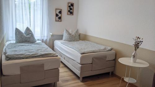a small room with two beds and a table at Meiers FeWo in Tremmen