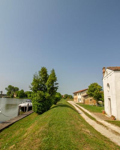 a canal with a boat parked next to a building at Residenze Di La' Dal Fiume in Caorle