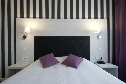 トワリーにあるAuberge de l'Etoileのベッドルーム1室(大型ベッド1台、紫色の枕付)