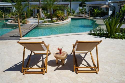 two chairs and a vase sitting next to a pool at Kalia Bingin - Adult only in Uluwatu