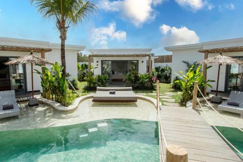 a villa with a swimming pool and a house at Kalia Bingin - Adult only in Uluwatu