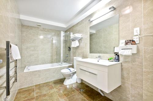 a bathroom with a sink and a toilet and a shower at Alexander Inn in Auckland