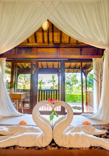 a bedroom with two swans wrapped in towels on a bed at Canggu Wooden Green Paradise in Canggu