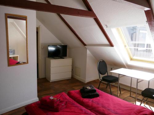 a bedroom with a red bed and a table and a television at Sleep in Hamburg St. Pauli in Hamburg