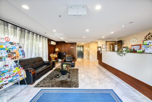 a lobby of a pharmacy with a couch and a counter at Alexander Inn in Auckland