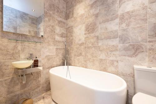 a bathroom with a tub and a sink and a toilet at JOIVY Cozy Apt near Edinburgh Castle in Edinburgh
