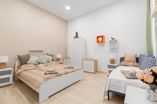 Habitación blanca con cama y sofá en Apartment Colourful, en Budapest