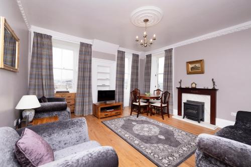 a living room with a couch and chairs and a table at JOIVY Cozy Apt near Edinburgh Castle in Edinburgh