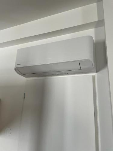 - un poêle blanc dans une chambre avec un mur blanc dans l'établissement Studio refait à neuf avec cuisine équipée R1, à Blaye