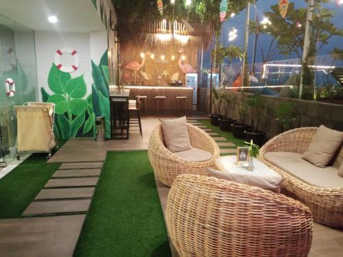 a restaurant with wicker chairs and a table and a bar at Zigna Kampung Batik in Solo