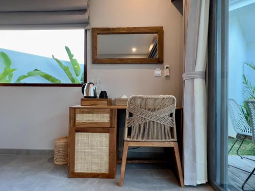 a desk with a chair and a mirror at Kalia Bingin - Adult only in Uluwatu
