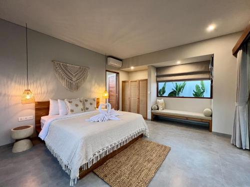 a bedroom with a large bed and a window at Kalia Bingin - Adult only in Uluwatu