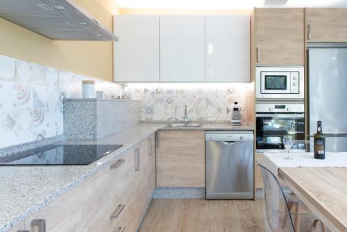 a kitchen with wooden cabinets and stainless steel appliances at Villa El Castañal con Piscina Privada in Vigo