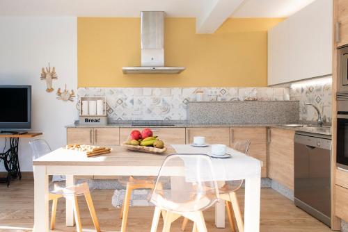 a kitchen with a table with a bowl of fruit on it at Villa El Castañal con Piscina Privada in Vigo