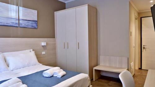 a bedroom with a bed and a white cabinet at Pianomare Riviera Apartments and Rooms in Imperia
